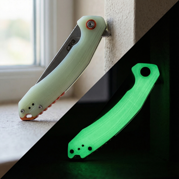 CJRB Gobi Glow-in-the-Dark knife resting on a dark textured surface, handle glowing faintly green